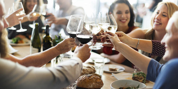 Group enjoy dinner and toasting with wine