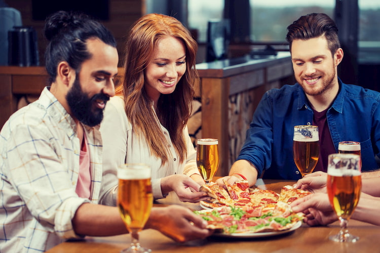 Group enjoying pizza and beer at lunch