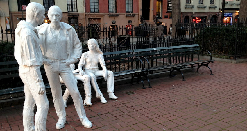the Gay Liberation art installation in Christopher Park in New York City, with Stonewall Inn in the background