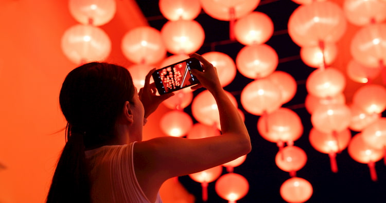 a woman takes a photo of red lanterns at a lunar new year festival