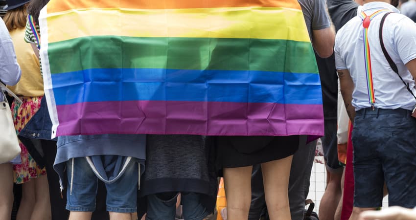 a group standing together under a pride flag