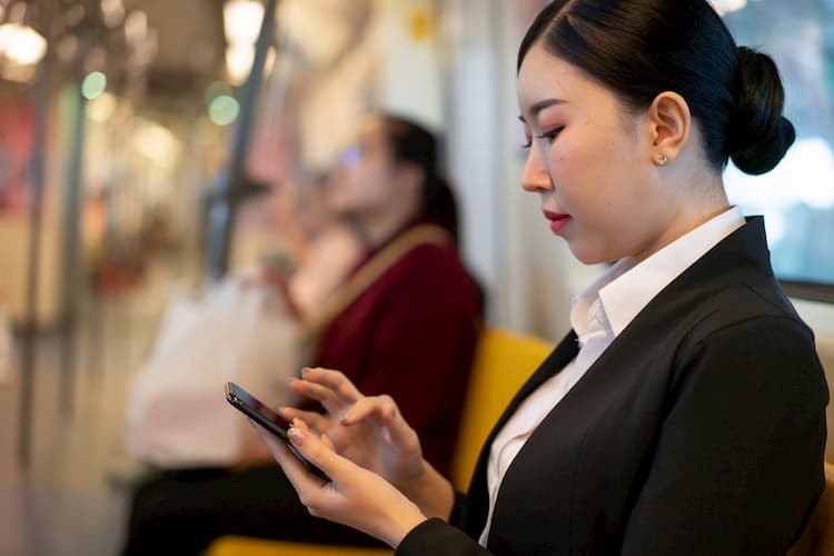 Woman working on phone on bus