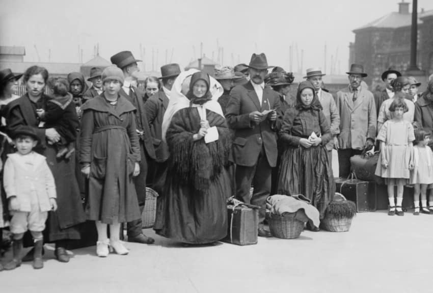 A black and white photograph of the immigrants arriving at Ellis Island