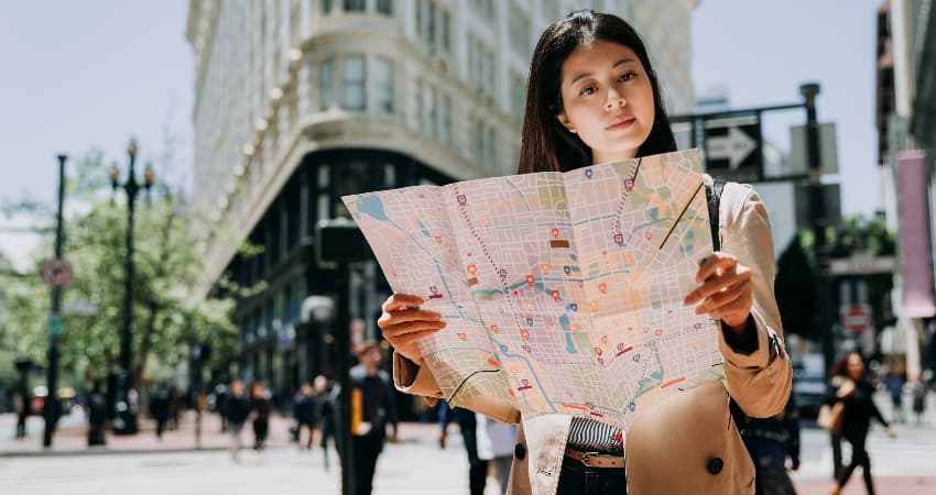 A woman on a city street consults a map