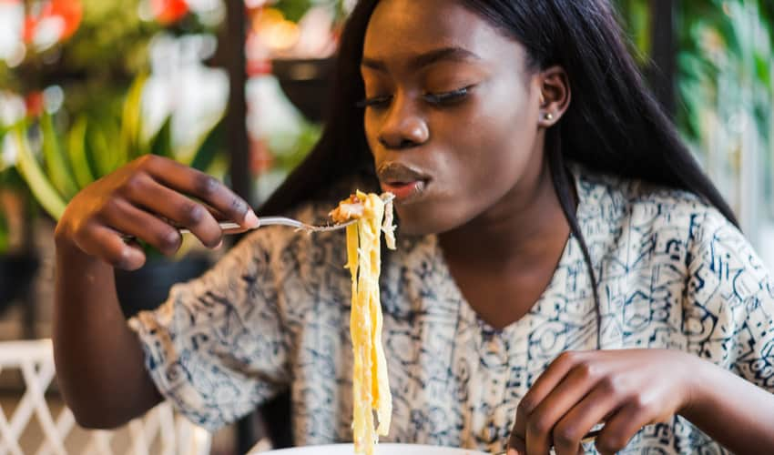 a woman eating Italian food at a restaurant 