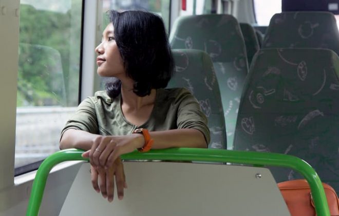 Woman looking out window on bus