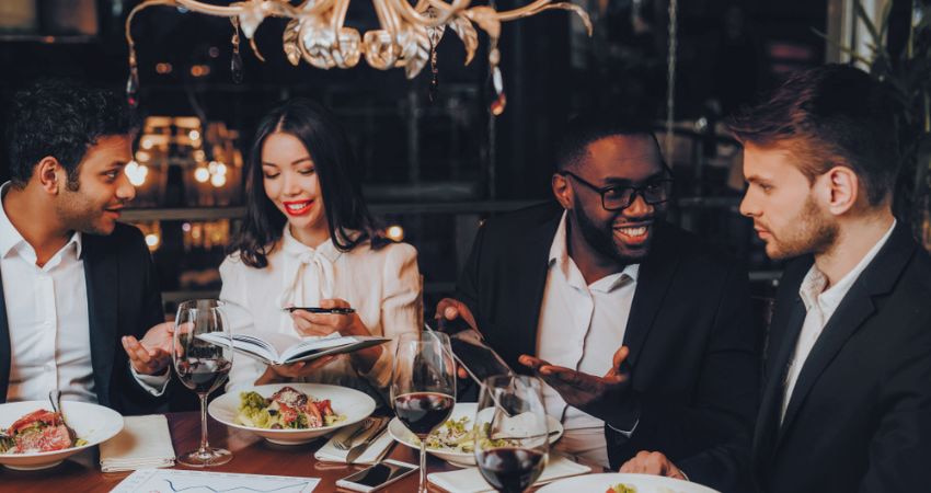 group of colleagues discussing work during a corporate dinner